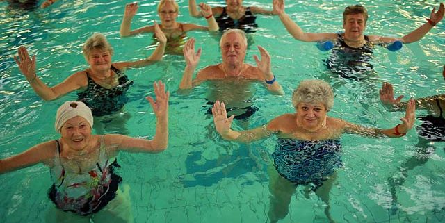 Zehn ältere Frauen und Männer bei der Aquagymnastik in einem Schwimmbecken
