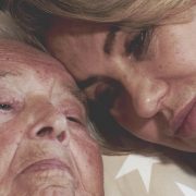 Eine betagte Frau im Krankenbett und eine junge Frau umarmen sich liebevoll