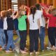 Eine Gruppe von Kindern führt in einem Turnsaal einen Tanz mit Tüchern auf