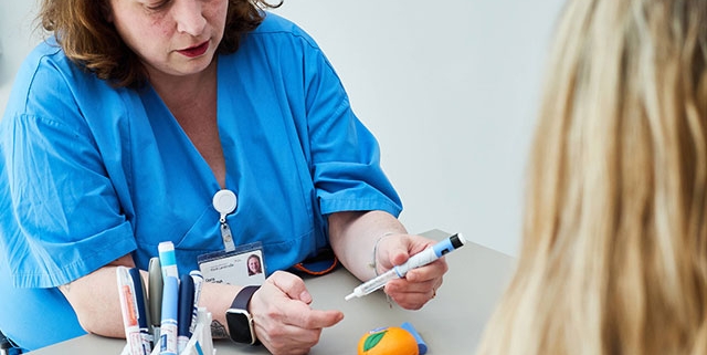 Eine Ärztin erklärt einer Patientin den Umgang mit einem Insulin-Pen